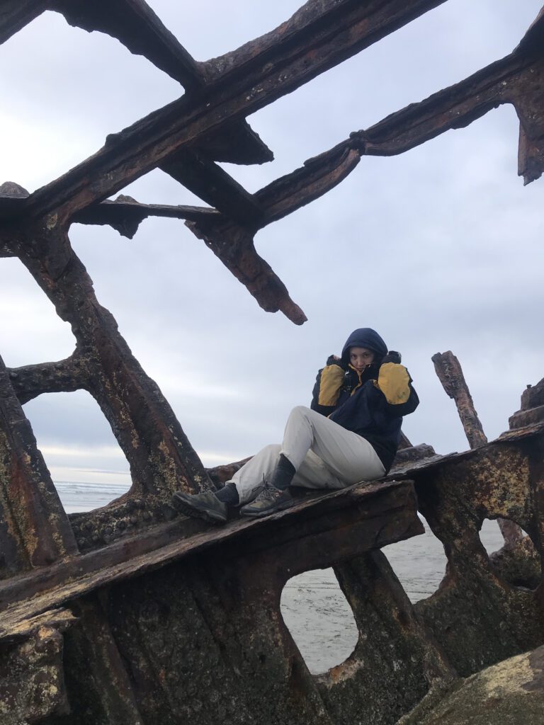 I am sitting on a shipwreck off Astoria Oregon. I have the hood of my rain jacket pulled up over my head so you cannot see my hair.